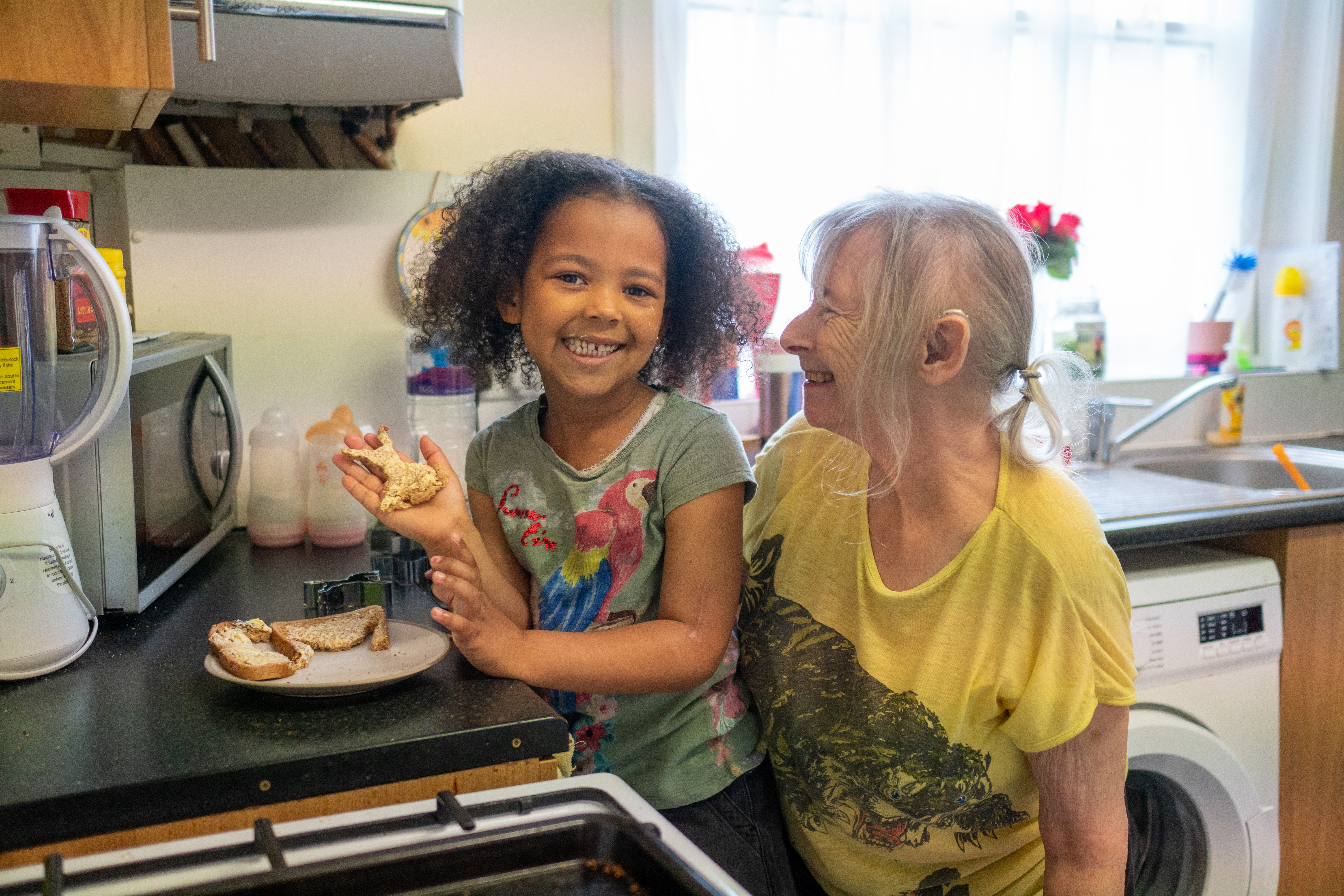 Older woman cooking with her granddaughter