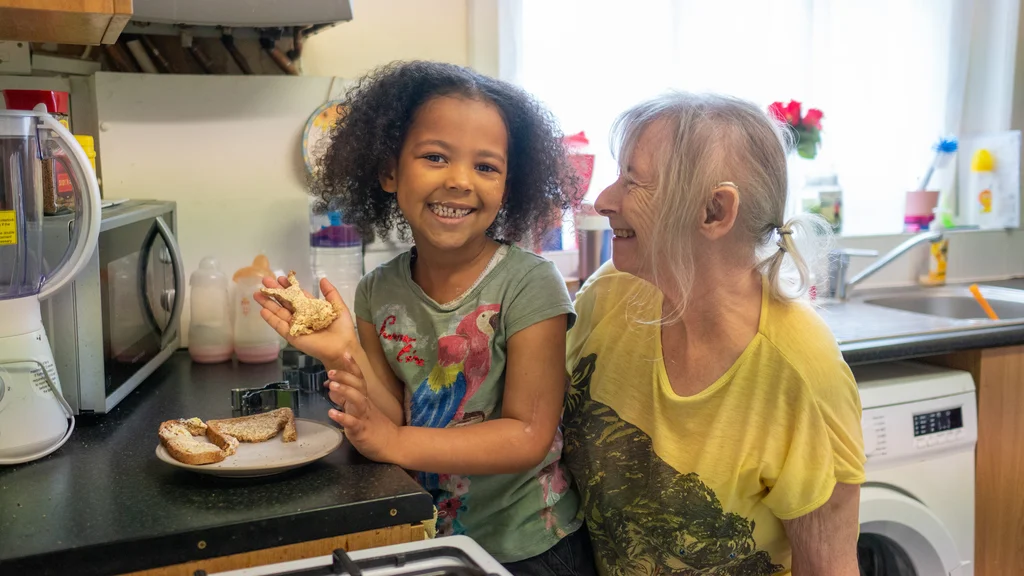 Older woman cooking with her granddaughter