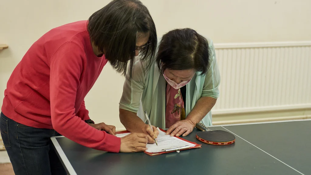 Older people writing on a notepad