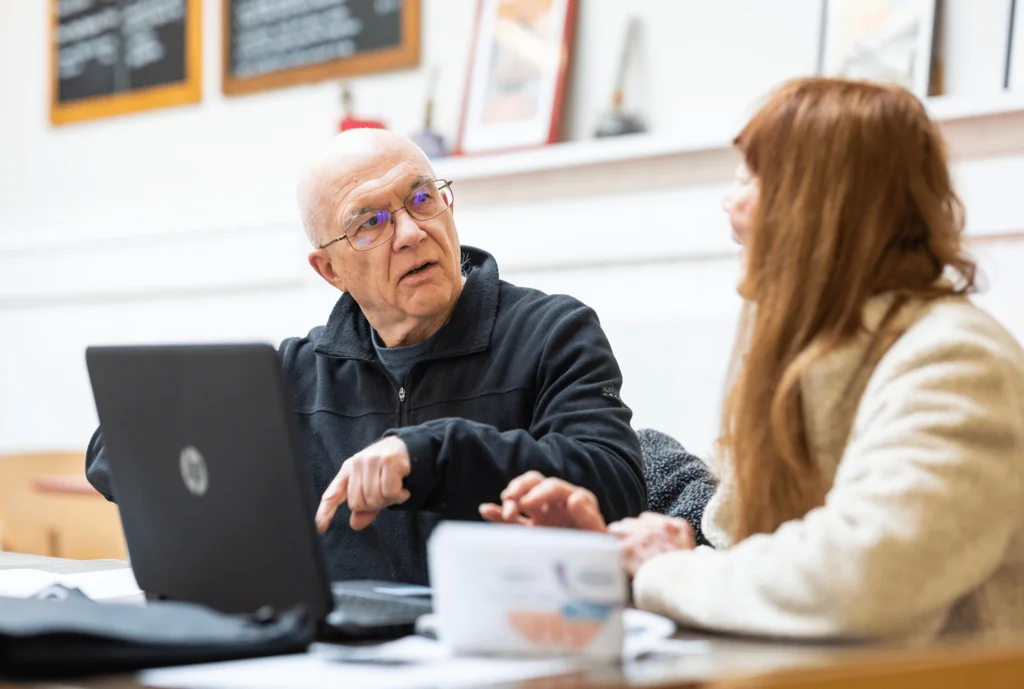 Two people using a laptop